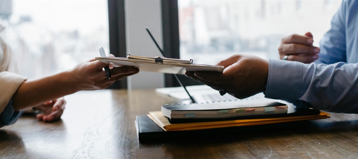 photo of one arm passing a clipboard to another one